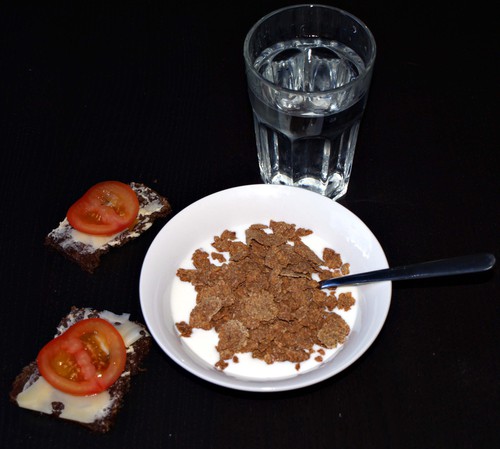 En rejäl frukost med vatten, fil, all bran, grovt bröd, ost, tomat