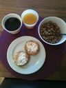 En skål med havrekuddar, nybakade scones med philadelphia ost, ett glas jucie och en kopp kaffe... 