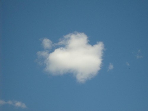 ett fluffigt moln på klarblå himmel